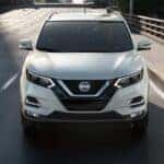 A white used 2021 Nissan Rogue Sport driving down a street