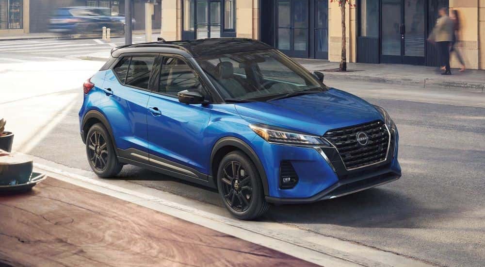 A blue used 2023 Nissan Kicks parked on a city street