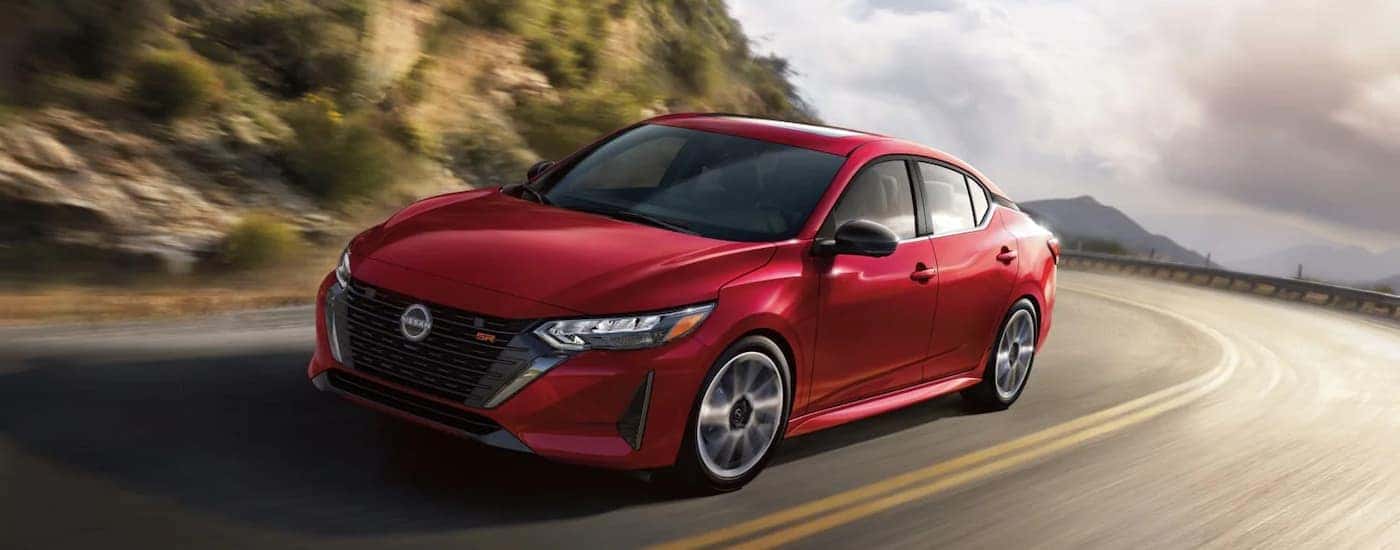 A red 2025 Nissan Sentra driving on a highway