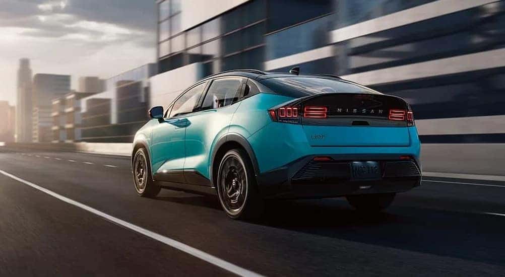 An aqua 2026 Nissan LEAF driving in a city.