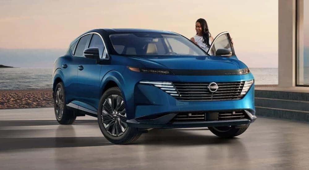 A person entering a blue 2025 Nissan Murano.
