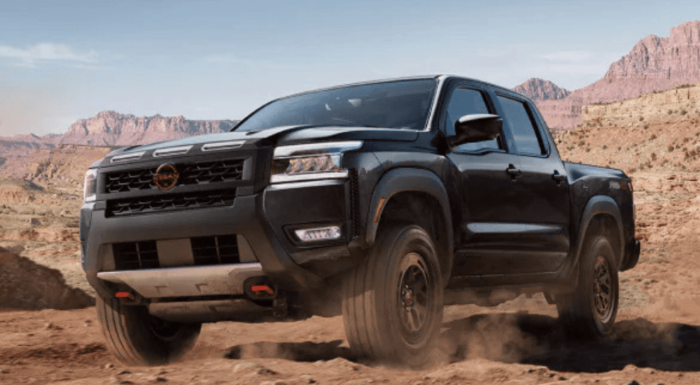 Black 2026 Nissan Frontier driving off-road