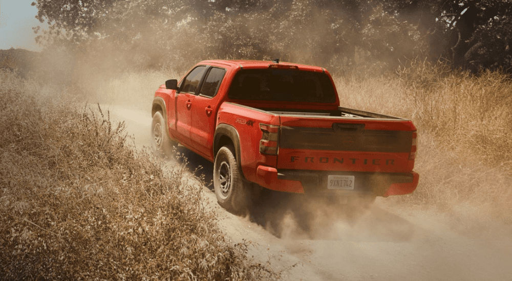 Orange 2026 Nissan Frontier driving off-road