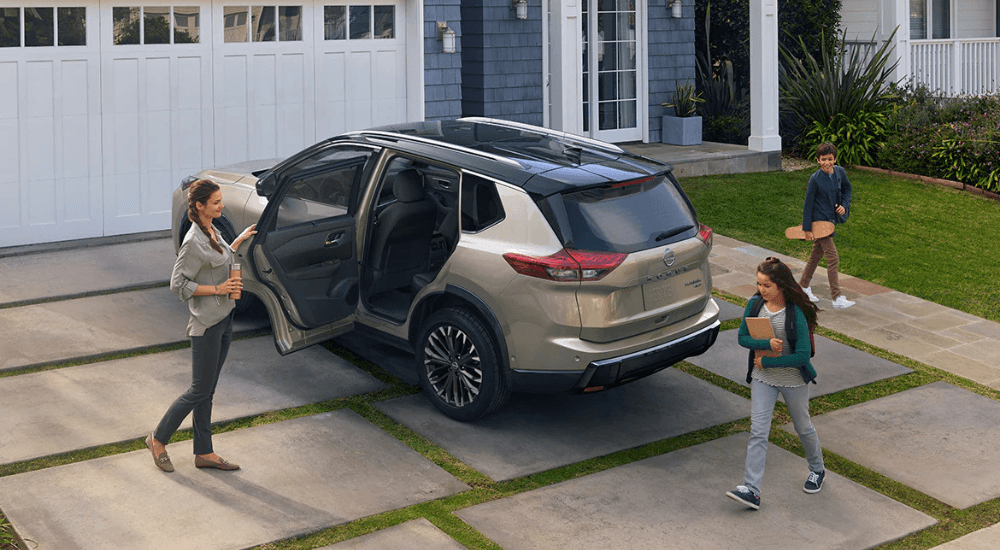 A tan 2026 Nissan Rogue parked on a driveway