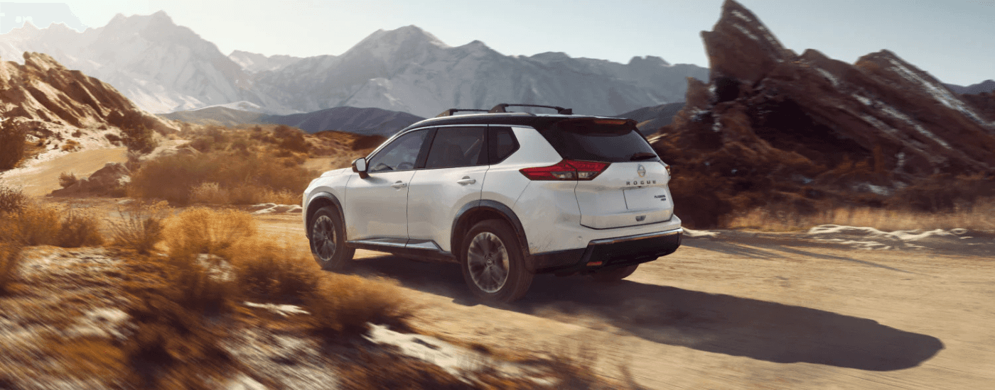 White 2026 Nissan Rogue driving down a trail