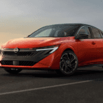 A red 2026 Nissan Sentra driving on a highway