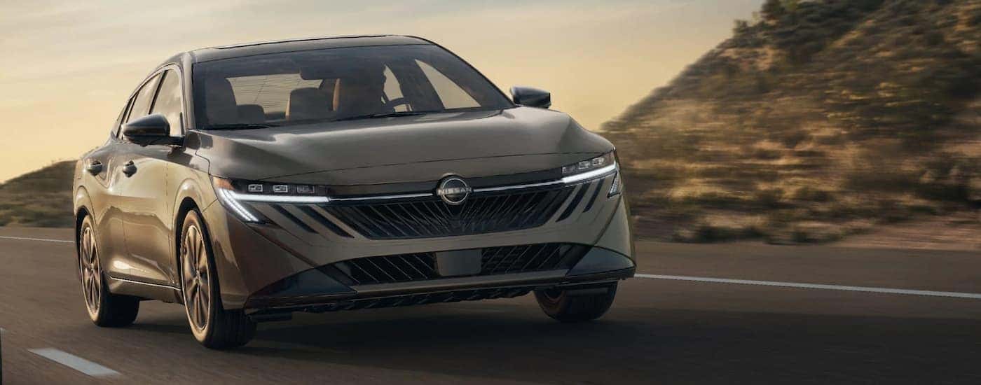 A tan 2026 Nissan Sentra SL driving down a road