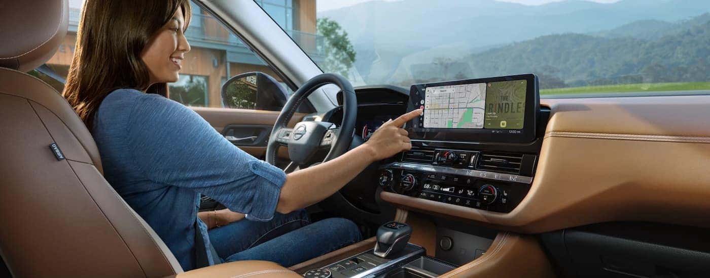 A person using the infotainment screen in a 2026 Nissan Pathfinder. 