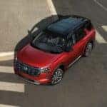 A red 2026 Nissan Pathfinder driving in an intersection.