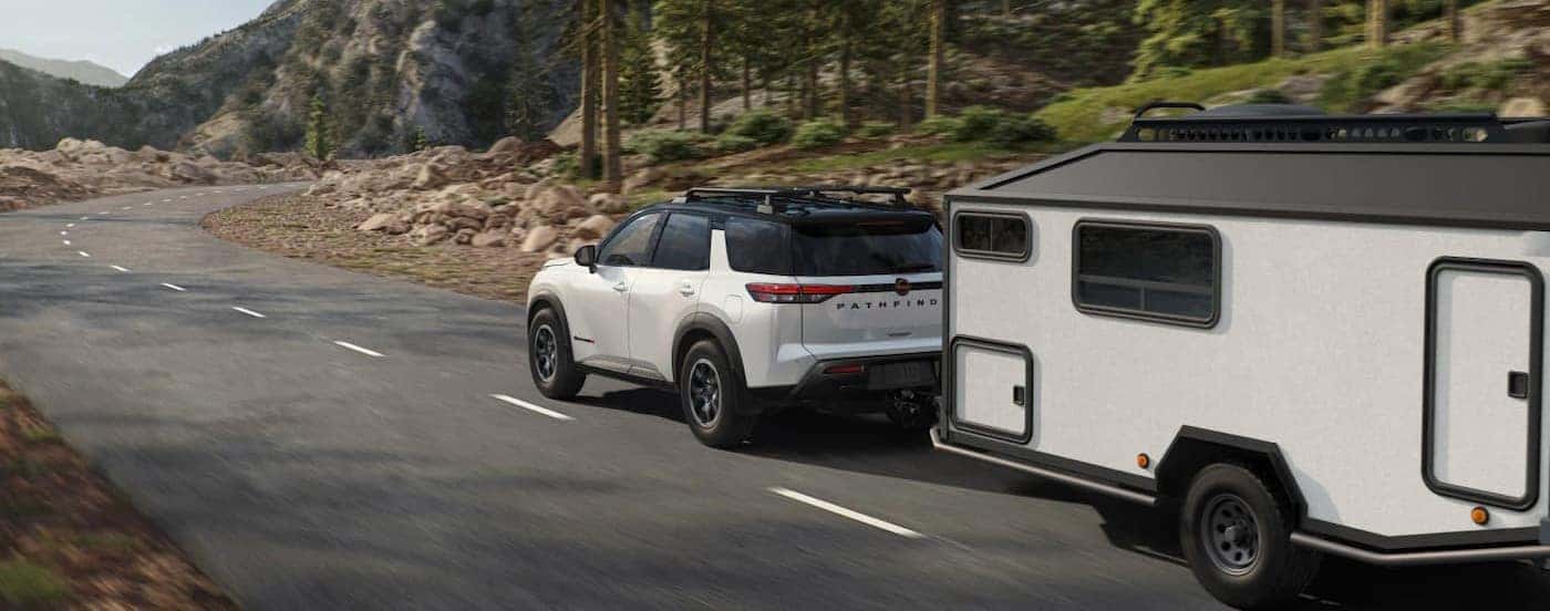 A white 2026 Nissan Pathfinder towing a trailer.