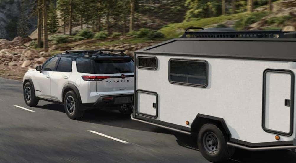 A white 2026 Nissan Pathfinder towing a trailer.