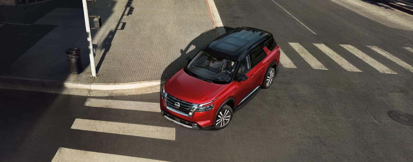 a red 2025 Nissan Pathfinder driving for sale near Urbana