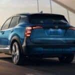 A blue 2026 Nissan Kicks driving in a city.