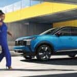 A person walking near a blue 2026 Nissan Kicks.