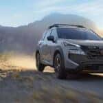 Grey 2026 Nissan Rogue driving off-road.