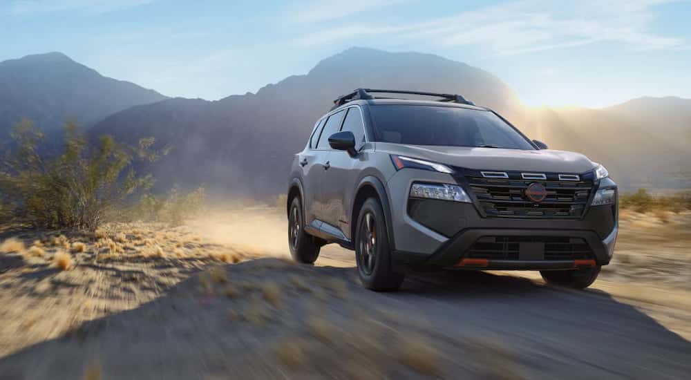 Grey 2026 Nissan Rogue driving off-road.