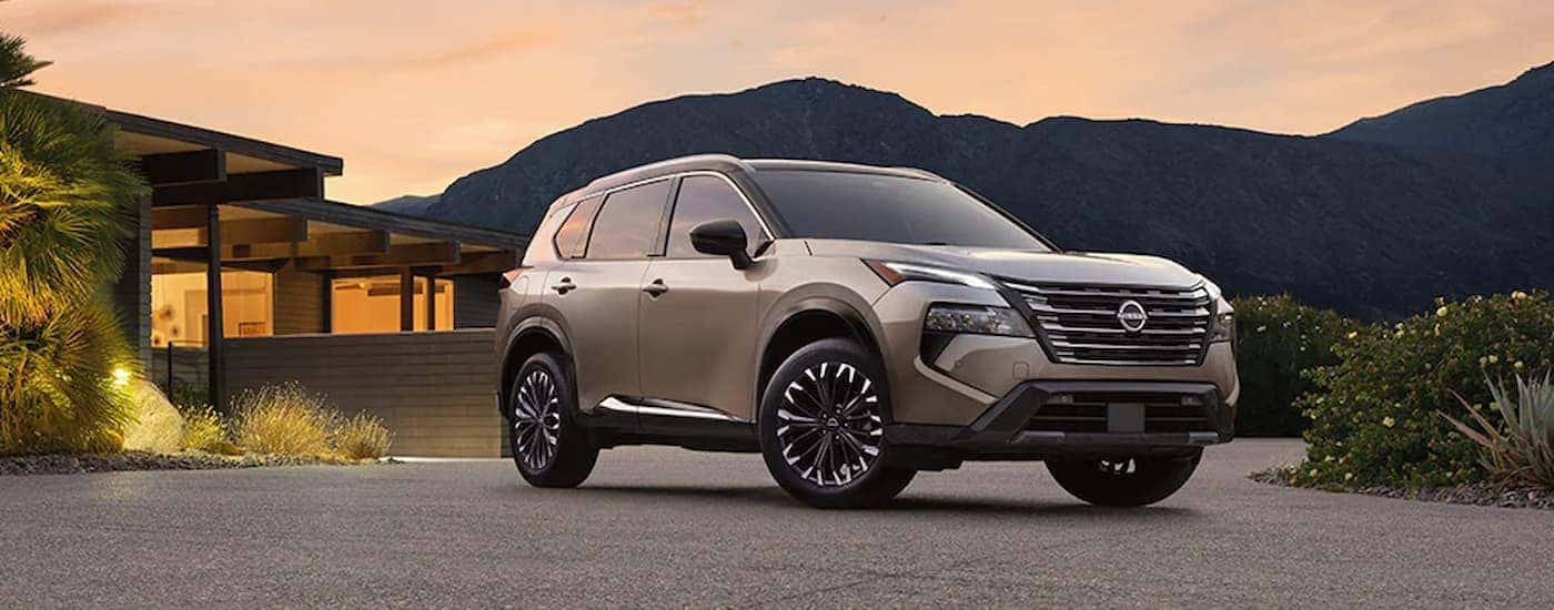 A tan 2025 Nissan Rogue parked in a driveway