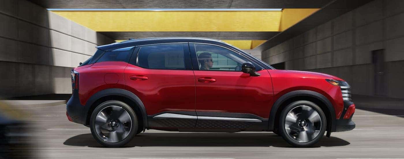 A red 2026 Nissan Kicks driving in a city