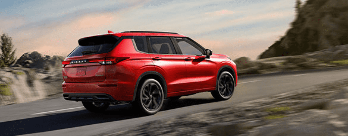 Red 2026 Nissan Rogue driving up a hill