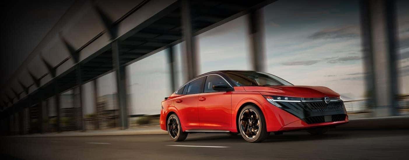 A red 2026 Nissan Sentra driving in a city.