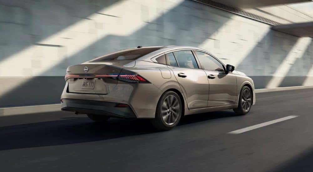 Tan 2026 Nissan Sentra from the rear driving down a road