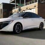 White 2026 Nissan Sentra driving through an intersection