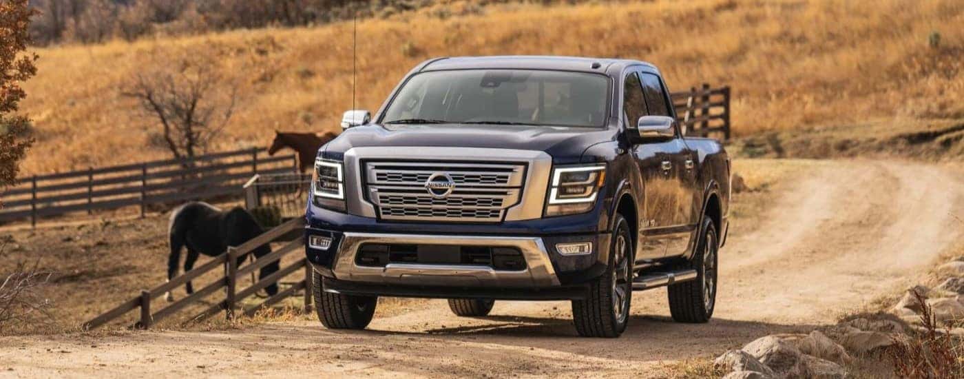 Blue 2021 Nissan TItan on a ranch with horses