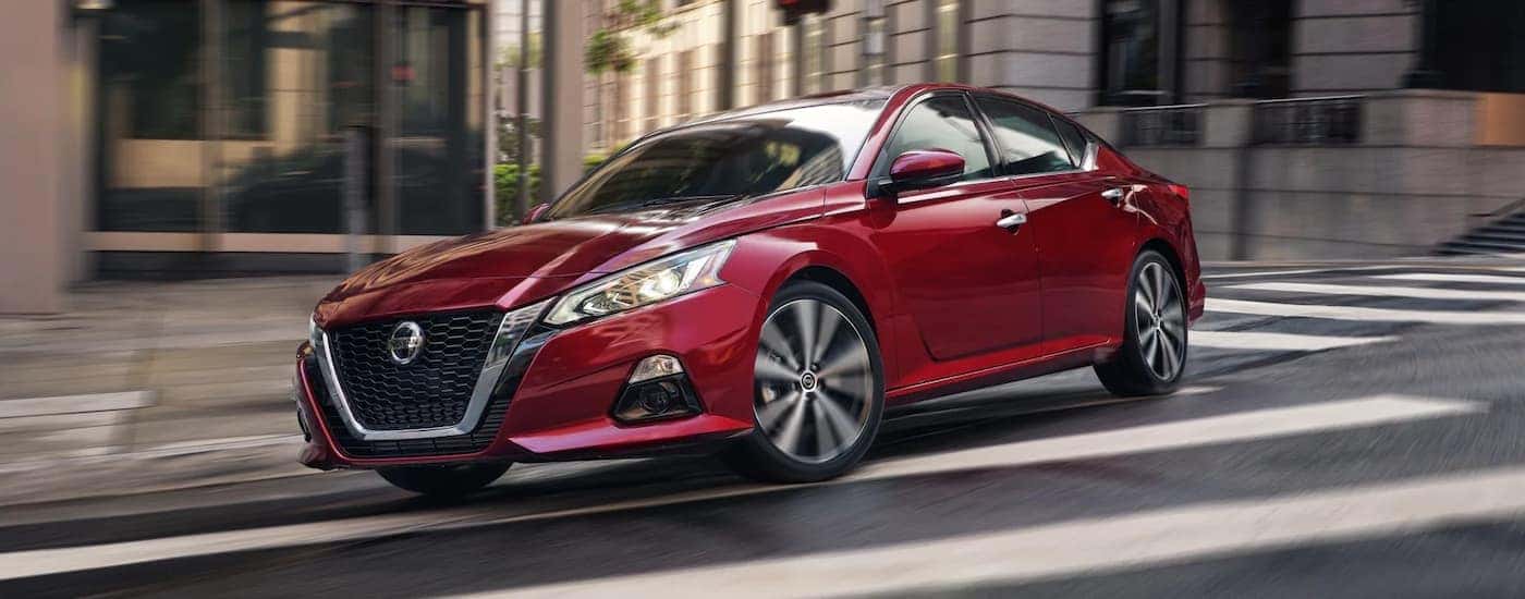 Red 2022 Nissan Altima turning onto a city street