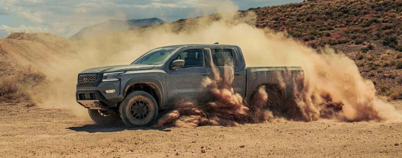 Grey 2023 Nissan Frontier driving off-road.