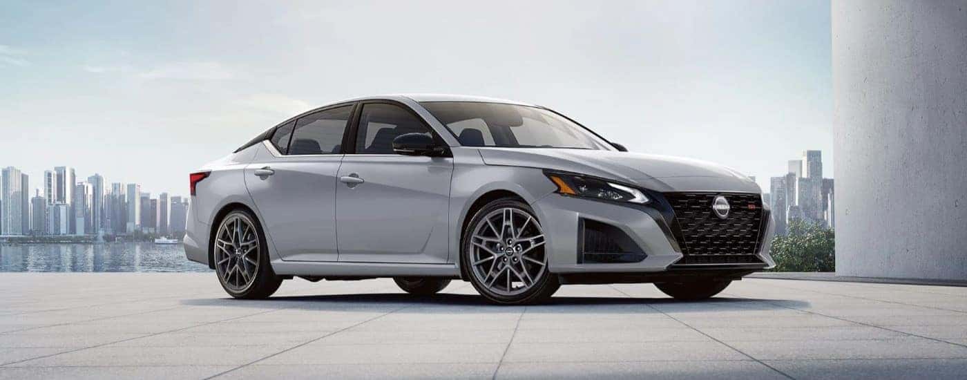 A white 2023 Nissan Altima SR is shown parked in front of city.