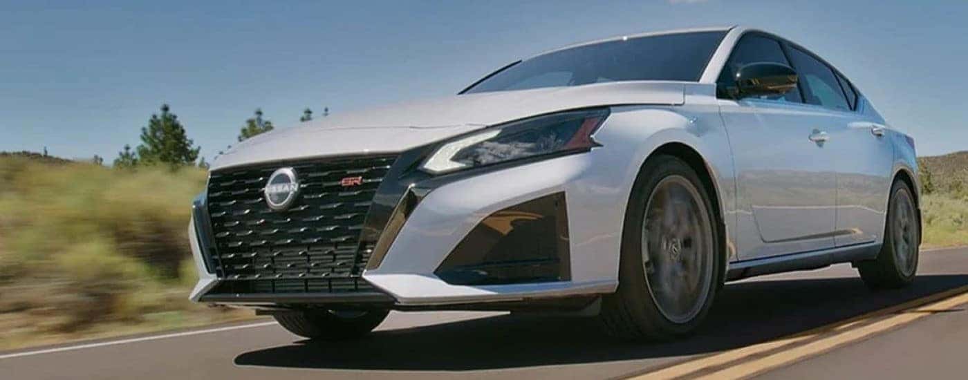 White 2024 Nissan Altima SR driving on the highway.