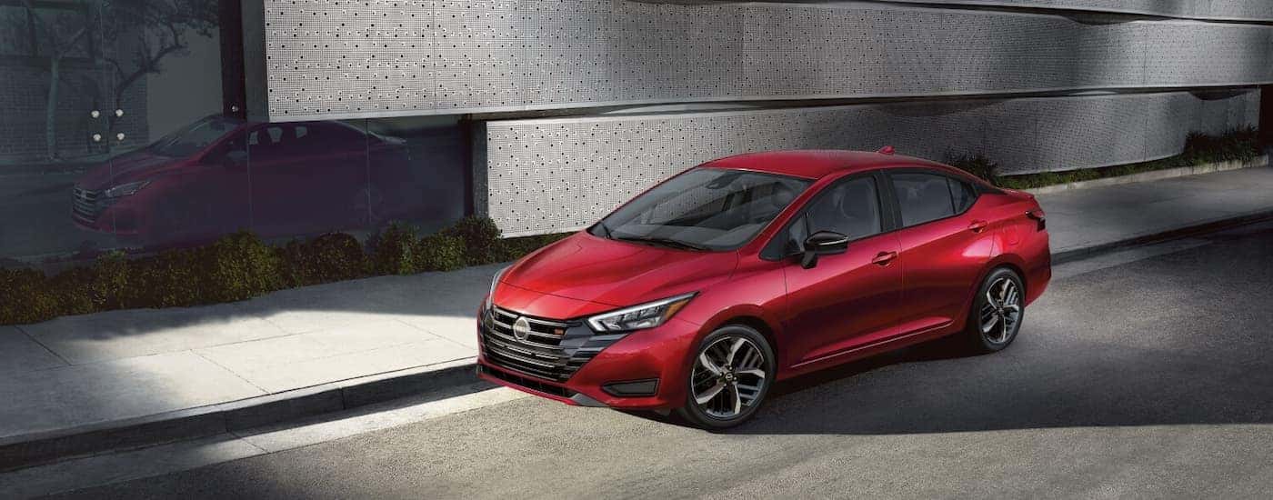 Red 2026 Nissan Versa parked on the side of a street