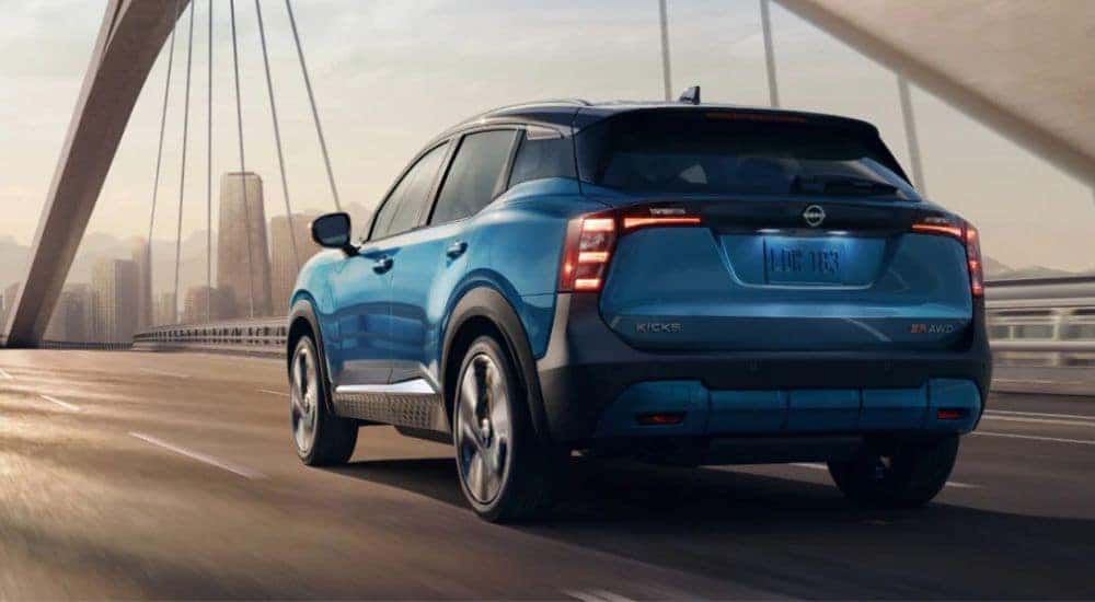 A blue 2026 Nissan Kicks SR AWD shown crossing a bridge.