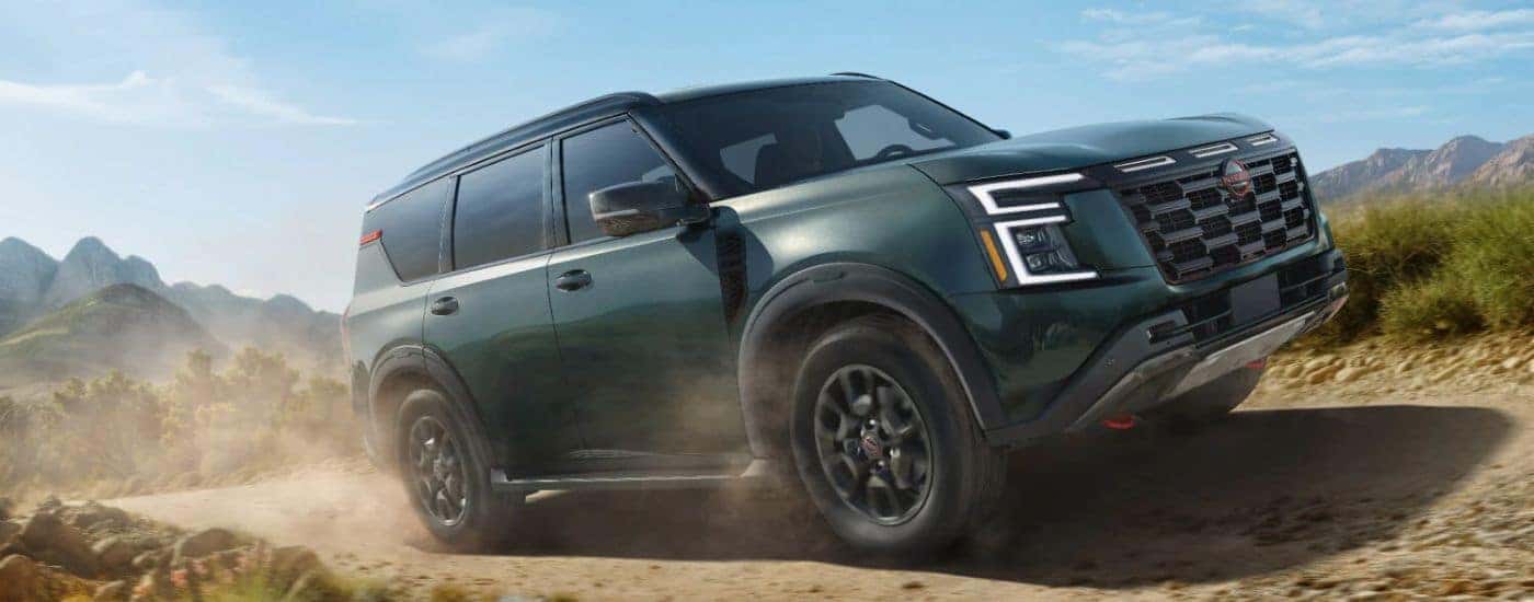 A green 2026 Nissan Armada shown driving a dirt road.