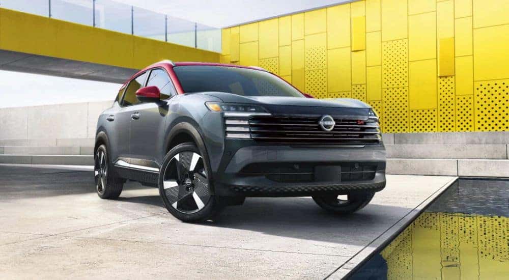 A parked gray 2026 Nissan Kicks SR AWD with red accents.