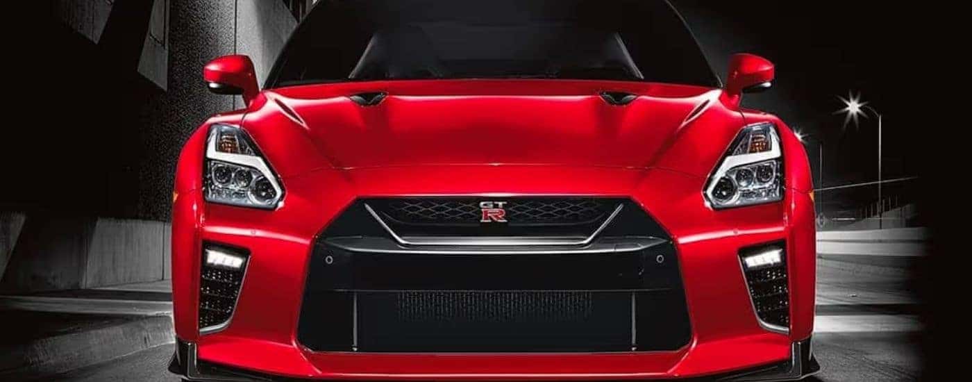 A red 2021 Nissan GT-R is shown from the front parked in a dark warehouse.