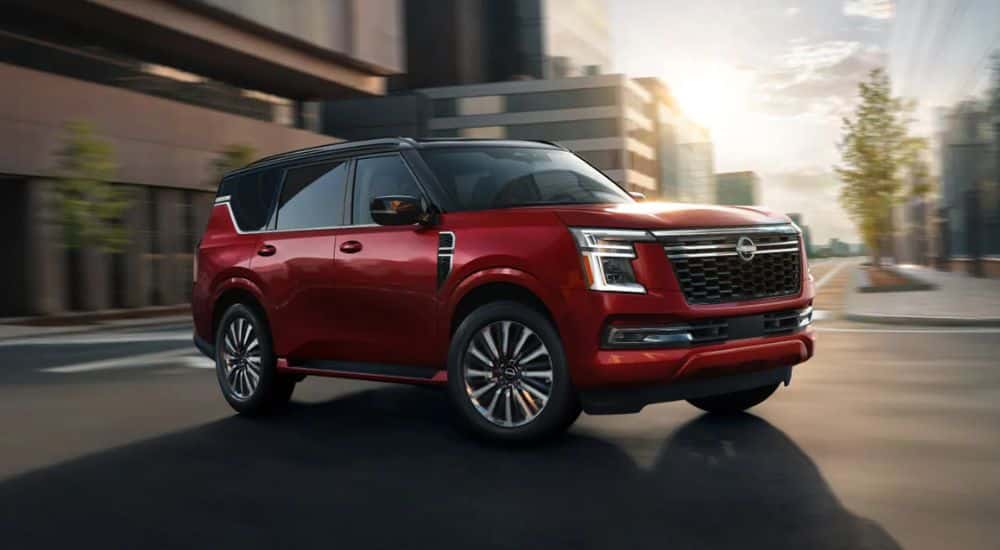 A red 2026 Nissan Armada Platinum Reserve 4WD is shown driving in a city.