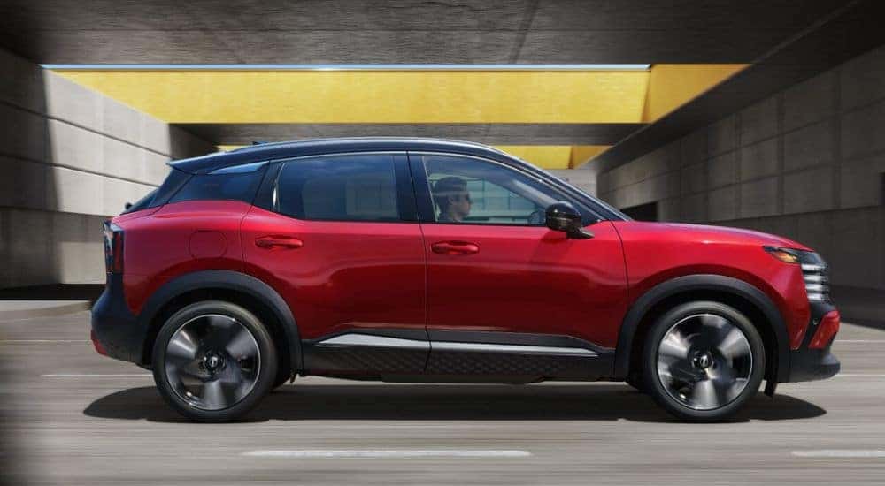 A red 2026 Nissan Kicks SR AWD shown from passenger side driving.