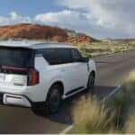 A white 2026 Nissan Armada Platinum Reserve 4WD driving a grass-lined road.