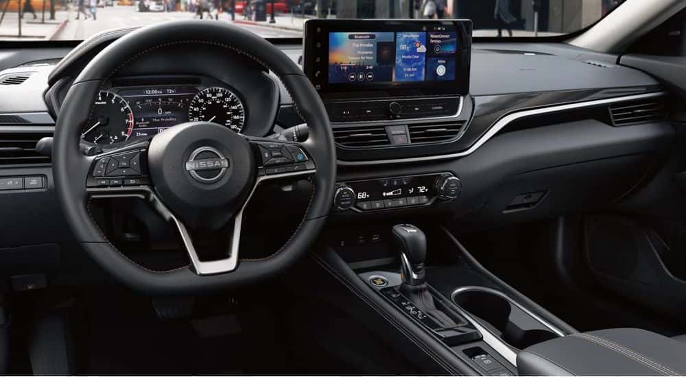 Interior view of a 2026 Nissan Altima steering wheel, gauge cluster and infotainment.