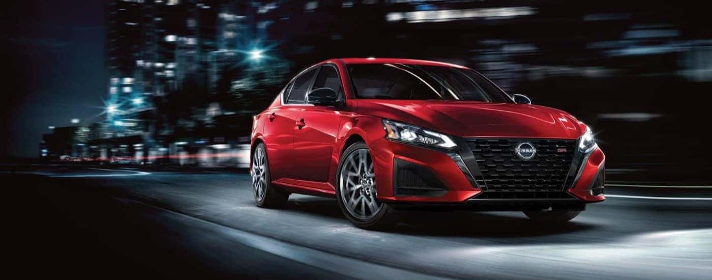 A red 2021 Nissan Altima is shown driving.