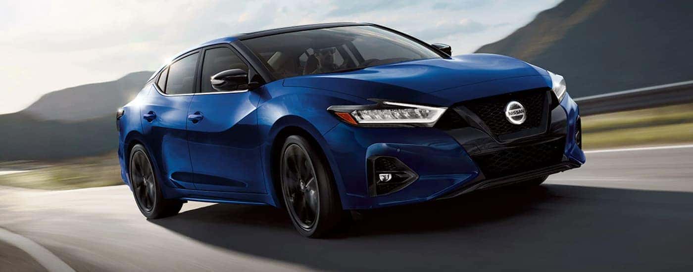 Blue 2021 Nissan Maxima driving on a road