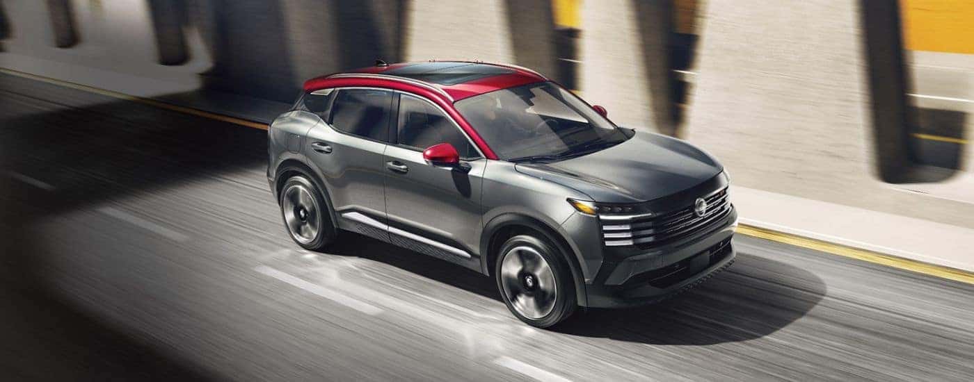 Grey 2026 Nissan Kicks with a red roof driving.