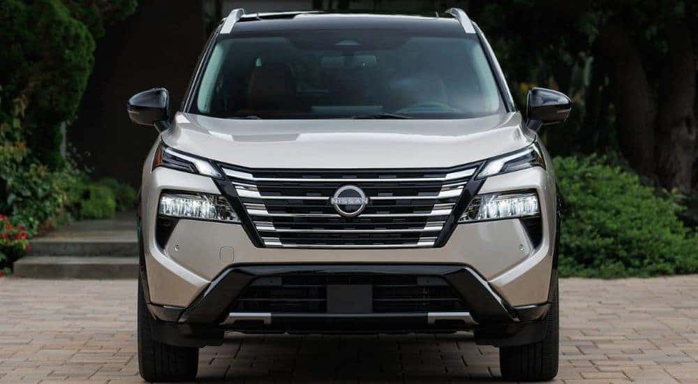 A sand-colored 2026.5 Nissan Rogue Platinum AWD shown parked head-on.