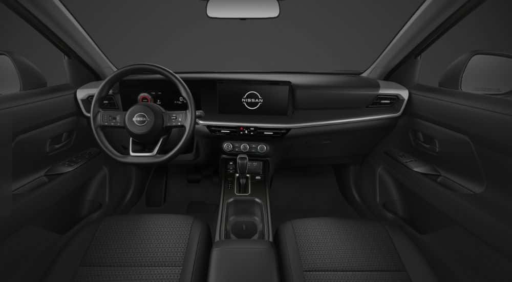 Black interior of a 2026 Nissan Kicks showing steering wheel and infotainment display.