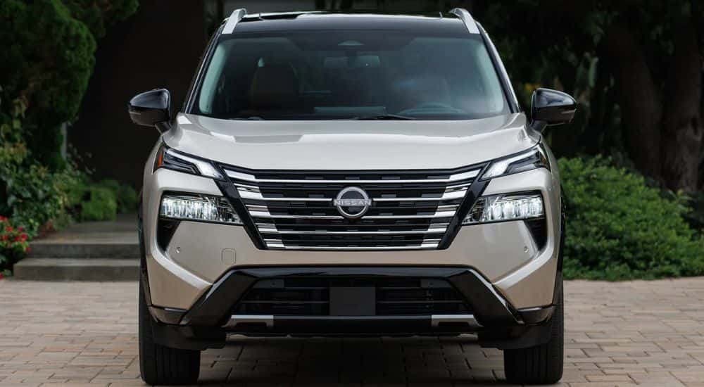 A sand-colored 2026.5 Nissan Rogue Platinum AWD shown parked head-on.