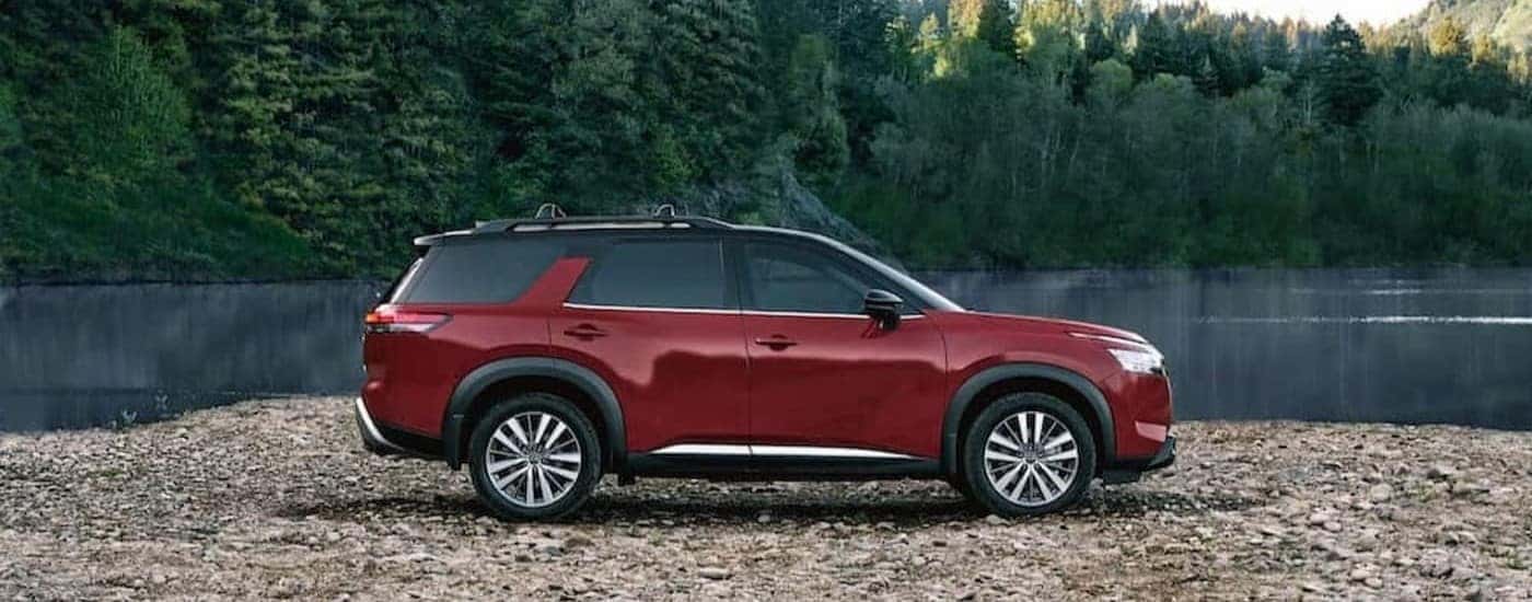 A red 2023 Nissan Pathfinder parked offroad.