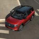 A red 2026 Nissan Pathfinder driving in a city.