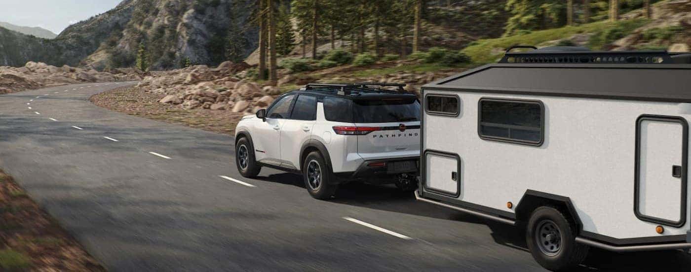 A white 2026 Nissan Pathfinder towing a trailer.