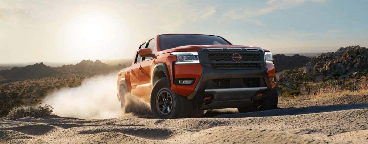 Red 2026 Nissan Frontier Crew Cab PRO-4X driving off-road.